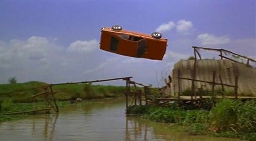 a car doing a movie stunt flipping over a river