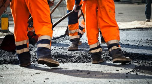 a team of road workers relaying a road