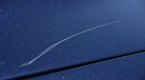 Close up of scratch on blue car paintwork