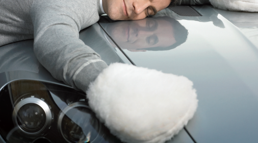 a person lying on their car