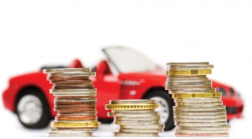 coins stacked up in front of a red toy car