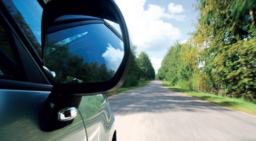 side picture under car wing mirror of the road ahead