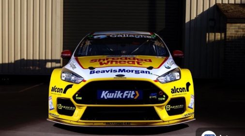 a yellow race car with kwik fit logo on the front of it