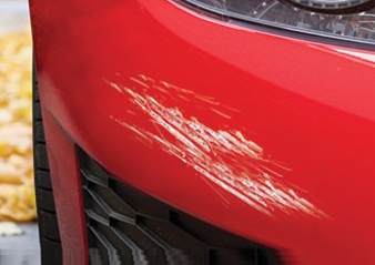 a red car with a scratch on the bumper