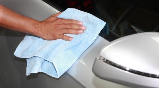 a person polishing a silver car