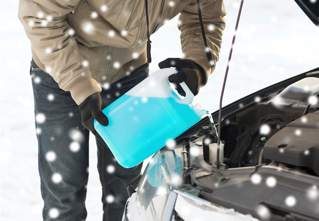 A man pouring antifreeze into a car