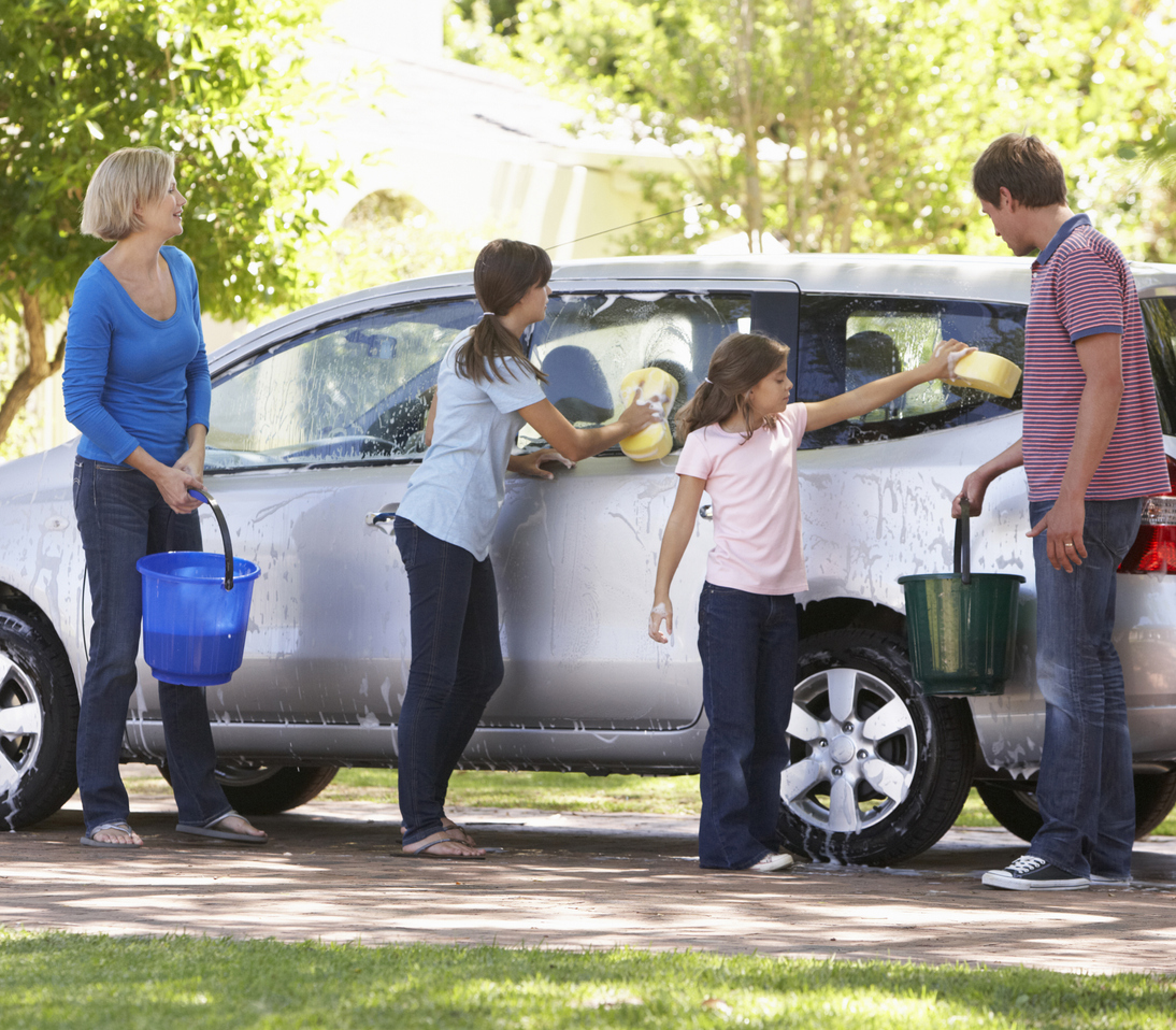 Family Washing Car Together With Buckets And Sponges.