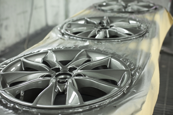 alloy wheels lined up to be repaired and refurbished painted silver