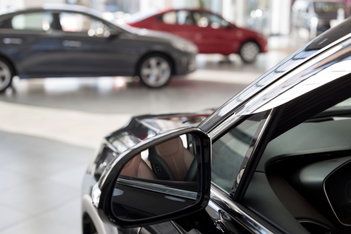 New cars at dealer showroom. Themed blur background with bokeh effect. Car auto dealership.