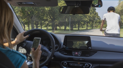 Woman driving and texting on cell phone and not paying attention to the road. Hit a man on a bicycle. Dangerous situation.