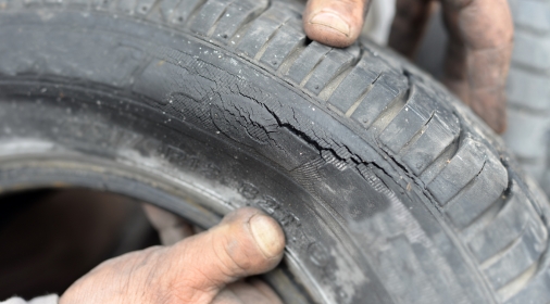 hands holding car tyre with crack