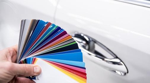 Man choosing color of his car with color sampler. Car foil wrapping colors picker