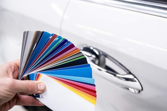 Man choosing colour of his automotive paint with colour sampler. 