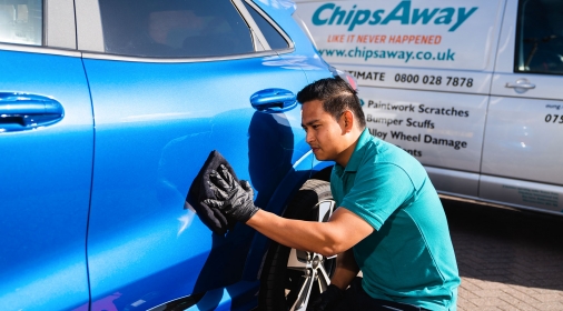 ChipsAway Specialist polishing blue car on customer's driveway