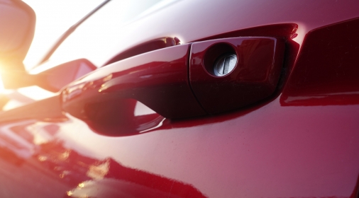 Door handle on freshly polished metallic red car door